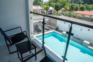 a balcony with a chair and a swimming pool at Sky's Villa Resort in Buff Bay