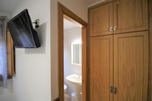 a bathroom with a sink and a cabinet and a television at Casa Campanilla Jaca in Jaca