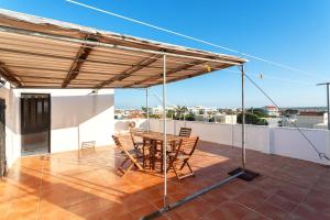 patio con tavolo e sedie sul tetto di Marya private rooms a Faro