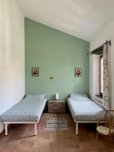 two beds in a room with green walls at B&B Casa Contento in Arcevia