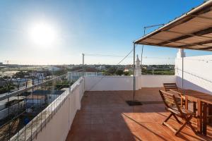 balcone con tavolo e sedie sul tetto di Marya private rooms a Faro