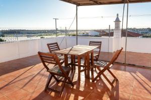 a wooden table and chairs on a roof at Marya private rooms in Faro