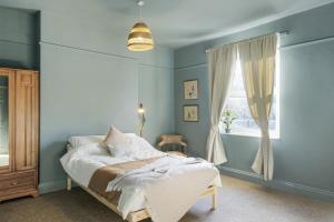 a bedroom with a bed and a window at Bright Apartment w Parking & Distant Sea Views in Minehead