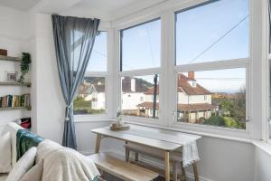 a living room with a table and a large window at Bright Apartment w Parking & Distant Sea Views in Minehead