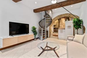 uma sala de estar com uma televisão, um sofá e uma mesa em Peaceful Getaway in the Heart of the City ID229 em Luxemburgo