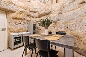 een keuken met een tafel en stoelen en een stenen muur bij Peaceful Getaway in the Heart of the City ID229 in Luxemburg