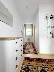 uma cozinha com armários brancos e um tapete no chão em Ferienwohnung Harzer Kleinod em Sankt Andreasberg