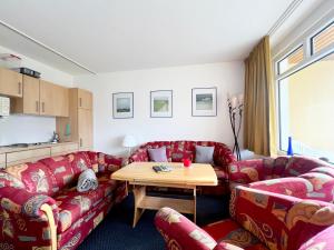 uma sala de estar com sofás vermelhos e uma mesa de madeira em Ferienwohnung Harzer Kleinod em Sankt Andreasberg