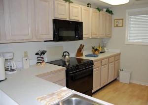 a kitchen with white cabinets and a black stove top oven at Heron Lake 3232 in North Myrtle Beach
