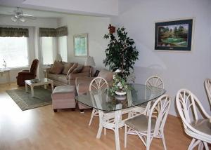 - un salon avec une table et des chaises en verre dans l'établissement Heron Lake 3232, à North Myrtle Beach