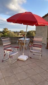 2 stoelen en een parasol op een patio bij Casa Fiore in Santa Luria