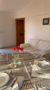 een tafel met borden en een vaas met een bloem erop bij Casa Fiore in Santa Luria