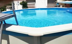 una piscina con una silla frente a ella en 3 bedrooms house with private pool enclosed garden and wifi at Chatun, en Chatún