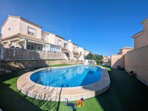 a swimming pool in the middle of a yard with houses at Cheerful 3 Bedroom Townhouse in El Galan EG2 in San Miguel de Salinas