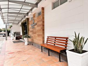 庫庫塔的住宿－HOTEL TASAJERO VIP，坐在大楼外的木凳