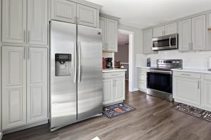 eine Küche mit weißen Schränken und einem Kühlschrank aus Edelstahl in der Unterkunft 4BR Centennial Charmer Trails Parks DTC in Centennial