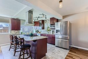 a kitchen with a stainless steel refrigerator and wooden cabinets at 3BD Family Friendly Walk to Huston Lake in Denver