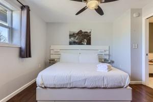 um quarto com uma cama branca e uma ventoinha de tecto em 3BD Family Friendly Walk to Huston Lake em Denver