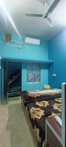 ein blaues Zimmer mit einem Bett und einer Decke in der Unterkunft Kishori ram guest house 5 minute walking distance from railway station in Ayodhya