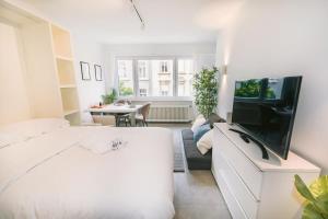 uma sala de estar com uma cama e uma televisão em Fully Renovated Studio - Luxembourg City em Luxemburgo