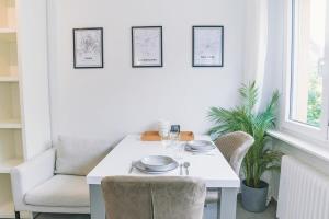 uma sala de jantar branca com uma mesa e cadeiras brancas em Fully Renovated Studio - Luxembourg City em Luxemburgo