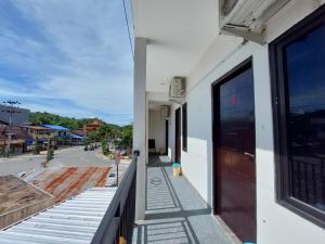 a balcony of a building with a door and a street at Guesthouse Cempaka in Sibengkok