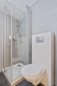 La salle de bains blanche est pourvue d'une douche et de toilettes. dans l'établissement Chic Apt Close to Kirchberg Shopping Centre ID157, à Luxembourg
