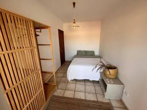 埃爾梅達諾的住宿－Integral Coliving Surf Yoga House，一间卧室配有一张床和一张带盆栽的桌子