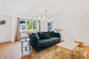 Una sala de estar con un sofá verde y una mesa. en Chic 1BR Near Kirchberg & Luxembourg Centre, en Luxemburgo