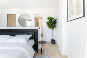 a bedroom with a bed with a mirror and a potted plant at City Luxury with City Views in Ville Haute in Luxembourg
