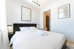 a white bedroom with a large white bed at City Luxury with City Views in Ville Haute in Luxembourg