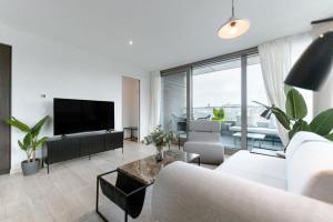 a living room with a couch and a tv at City Luxury with City Views in Ville Haute in Luxembourg