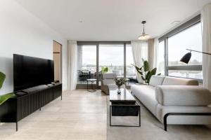 sala de estar con sofá blanco y TV de pantalla plana en City Luxury with City Views in Ville Haute ID174 en Luxemburgo