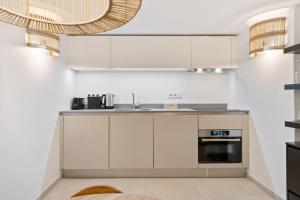 una cocina con armarios blancos y fregadero en Elegant 1BR Retreat in Peaceful Grund en Luxemburgo