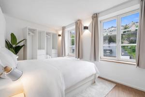 1 dormitorio blanco con 1 cama grande y ventanas en Modern Apt in Old Town w Panoramic View ID4, en Luxemburgo