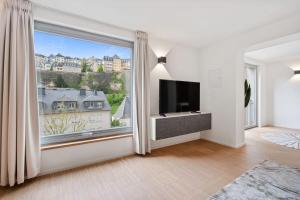 a living room with a large window with a flat screen tv at Modern Apt in Old Town w Panoramic View ID4 in Luxembourg