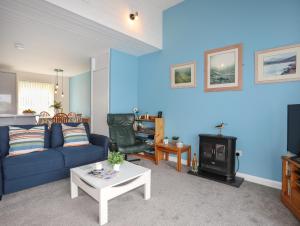 een blauwe woonkamer met een bank en een fornuis bij Waters Edge Ymyl Y Dwr in Y Felinheli