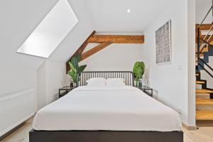 a bedroom with a white bed in a room with stairs at Escape to Clausen Stylish Apartment ID212 in Luxembourg