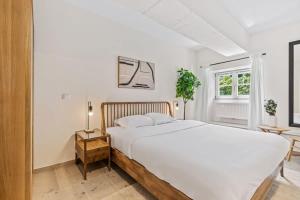 a white bedroom with a large bed and a window at Clausen Charm Contemporary Retreat ID210 in Luxembourg