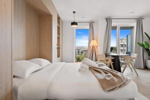 ein Schlafzimmer mit einem großen weißen Bett und einem Tisch in der Unterkunft Premium City Stay in Cessange ID204 in Luxemburg (Stadt)
