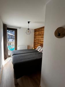 a bedroom with a bed and a large window at Chalet Martin Belle-Vue in Aime-La Plagne
