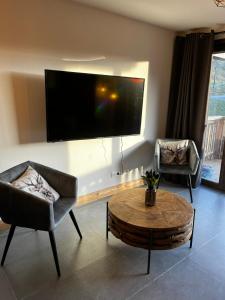 a living room with a large flat screen tv on the wall at Chalet Martin Belle-Vue in Aime-La Plagne