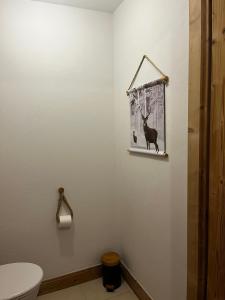 a bathroom with a picture of a deer on the wall at Chalet Martin Belle-Vue in Aime-La Plagne