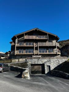 a large building with a car parked in front of it at Chalet Martin Belle-Vue in Aime-La Plagne