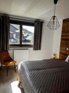 a bedroom with a bed and a large window at Chalet Martin Belle-Vue in Aime-La Plagne