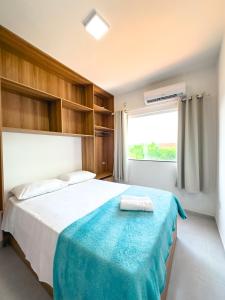 Un dormitorio con una cama con una manta azul. en Village Mariah en Coroa Vermelha