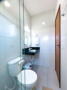 La salle de bains blanche est pourvue de toilettes et d'un lavabo. dans l'établissement Village Mariah, à Coroa Vermelha