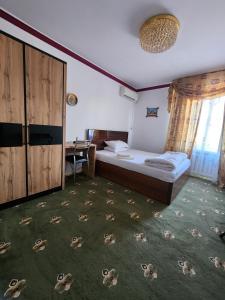 a hotel room with a bed and a desk and a bedroom at Heyvah - Guest House in Tashkent in Tashkent