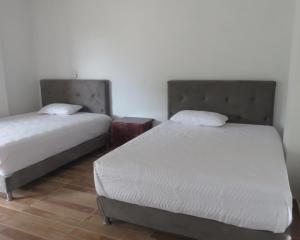 two beds in a room with two beds sidx sidx sidx sidx at HOTEL PURA VIDA in Santa Rosa de Cabal