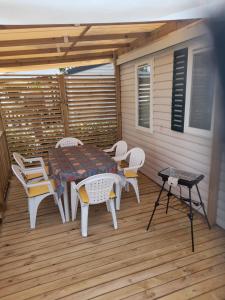 a patio with a table and chairs on a deck at Mobil Home 6 couchages in Vic-la-Gardiole